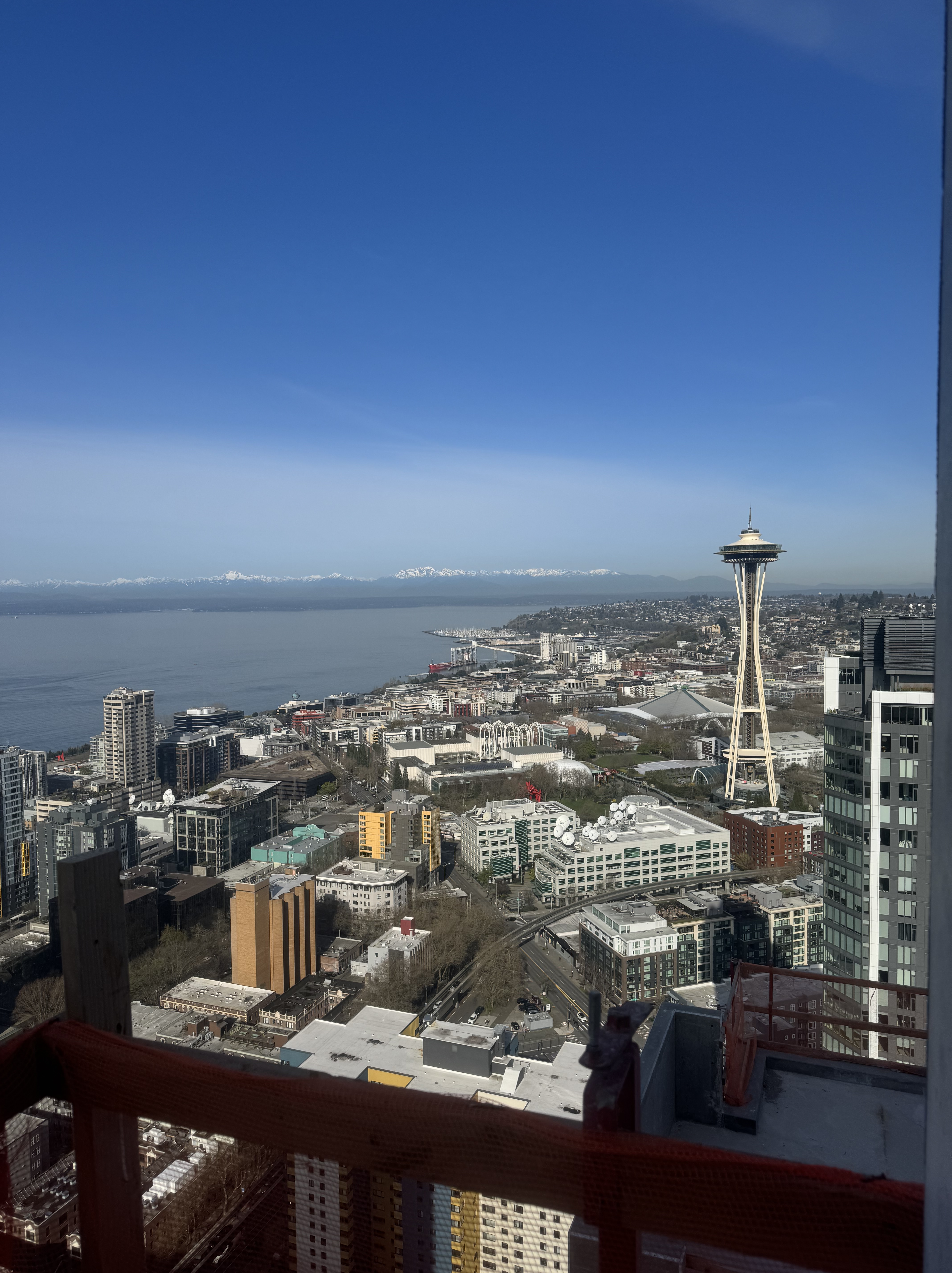 A cityscape with a tall tower and water in the background.